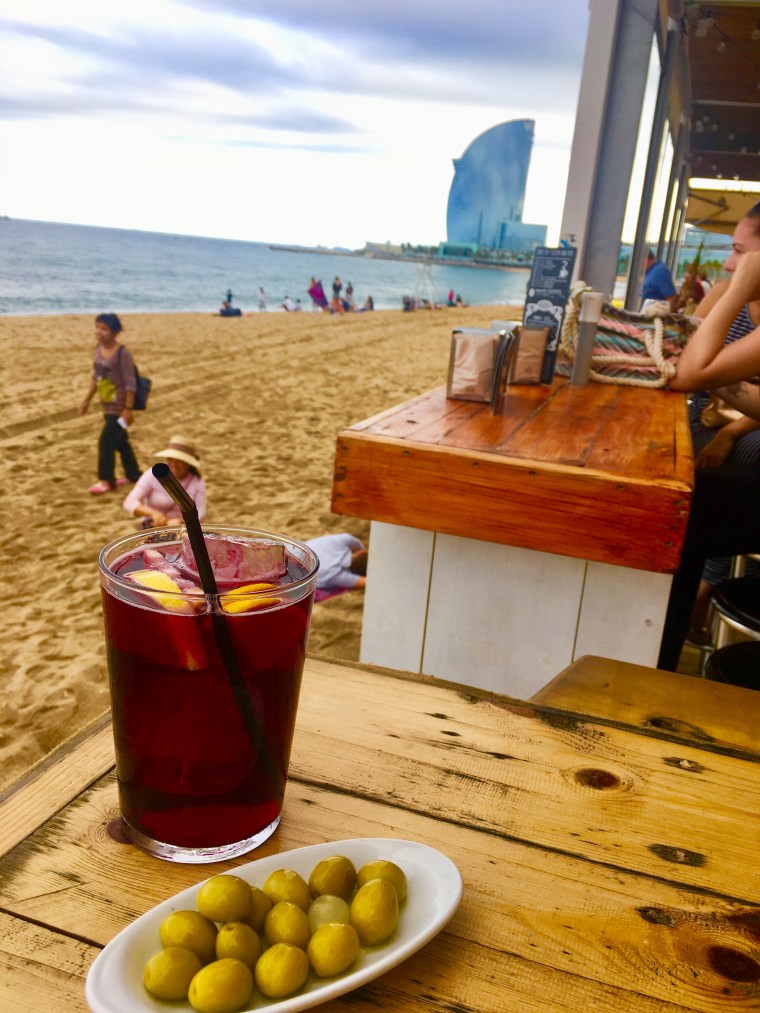 Blick von einem Strandcafé auf das Hotel W in Barcelona. Im Vordergrund: Sangria und Oliven
