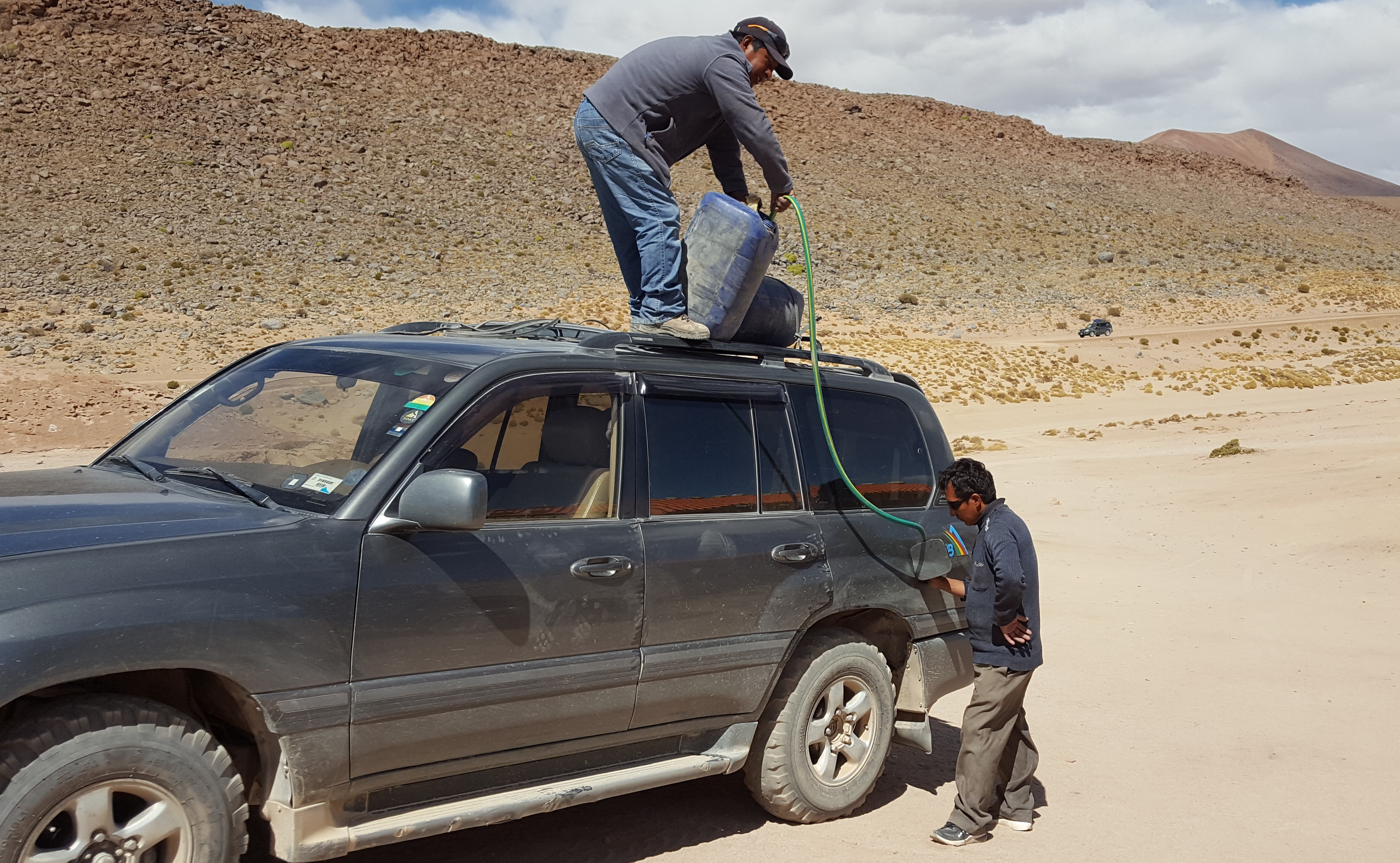 Das Auto wird in der Wüste aufgetankt.